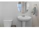 Cozy half bathroom featuring a pedestal sink, and a framed oval mirror at 603 Jewel St, Brighton, CO 80603