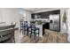 Modern kitchen features an island with bar stool seating and stainless steel refrigerator at 603 Jewel St, Brighton, CO 80603