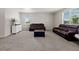 Spacious living room features neutral carpet, a leather sofa set, and plenty of natural light at 603 Jewel St, Brighton, CO 80603