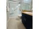 Bright bathroom with walk-in shower, grab bar, and single sink vanity with dark cabinets at 345 Fillmore St # 203, Denver, CO 80206