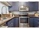 A modern kitchen equipped with stainless steel appliances and blue cabinets, perfect for cooking at 345 Fillmore St # 203, Denver, CO 80206