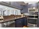 A cozy kitchen featuring blue cabinets, stainless steel appliances, and sleek countertops at 345 Fillmore St # 203, Denver, CO 80206