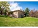 Well-maintained backyard featuring lush green grass, mature trees, and the home's brick exterior at 2615 Oak Dr # 7, Lakewood, CO 80215