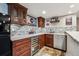 Wet bar features custom cabinetry, beverage fridge, mosaic backsplash and granite countertops with stainless sink at 2615 Oak Dr # 7, Lakewood, CO 80215