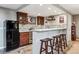 Basement bar with granite countertops, dark cabinets, stainless appliances, and seating for casual entertaining at 2615 Oak Dr # 7, Lakewood, CO 80215