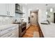Well-equipped kitchen with stainless steel appliances, white cabinetry, and hardwood floors at 2615 Oak Dr # 7, Lakewood, CO 80215