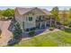 Stunning view of the home's exterior with a two-story deck supported by stone pillars and a professionally landscaped yard at 4965 Bierstadt Loop, Broomfield, CO 80023
