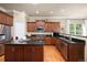 A kitchen with stainless steel appliances, dark countertops, wood floors, and wood cabinets at 4965 Bierstadt Loop, Broomfield, CO 80023