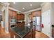 A kitchen with stainless steel appliances, wood floors, dark countertops, and wood cabinets at 4965 Bierstadt Loop, Broomfield, CO 80023