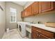 A laundry room with upper and lower cabinets, a utility sink, a window, and a washer and dryer at 4965 Bierstadt Loop, Broomfield, CO 80023