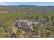 Scenic aerial view of a large estate nestled among the trees with mountain views at 2817 Keystone Dr, Evergreen, CO 80439
