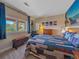 Bright bedroom featuring a colorful quilt and large windows with green treetop views at 2817 Keystone Dr, Evergreen, CO 80439