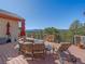 Relaxing deck features stylish patio furniture and spectacular mountain views beyond trees at 2817 Keystone Dr, Evergreen, CO 80439