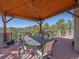 Outdoor dining on deck with views of trees and distant snow-capped mountains at 2817 Keystone Dr, Evergreen, CO 80439