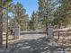 Gated entrance featuring stone pillars with street numbers, enhancing curb appeal and security at 2817 Keystone Dr, Evergreen, CO 80439