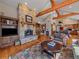 Inviting living room featuring a stone fireplace and exposed wooden beams at 2817 Keystone Dr, Evergreen, CO 80439