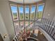 Grand staircase showcasing a chandelier and large windows with views of the outdoor deck at 2817 Keystone Dr, Evergreen, CO 80439