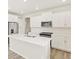 Modern white kitchen featuring an island, stainless steel appliances, and sleek countertops at 1918 S Coolidge Way, Aurora, CO 80018