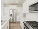 Modern white kitchen featuring an island, stainless steel appliances, and sleek countertops at 1918 S Coolidge Way, Aurora, CO 80018