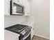 Modern kitchen features stainless steel appliances, white cabinets, and white backsplash at 1918 S Coolidge Way, Aurora, CO 80018