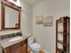 Well decorated half bath with elegant granite countertop, and decorative mirror at 8646 Fawnwood Dr, Castle Pines, CO 80108