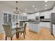 Bright eat-in kitchen with white cabinets, stainless steel appliances, and hardwood floors at 8646 Fawnwood Dr, Castle Pines, CO 80108