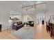 Bright, open-concept living room with a view of the staircase, kitchen, and front entrance at 8646 Fawnwood Dr, Castle Pines, CO 80108