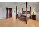 Spacious main bedroom featuring a four-poster bed, wood floors and large closet at 8646 Fawnwood Dr, Castle Pines, CO 80108