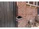 Damaged brick pillar with missing bricks next to a weathered, gray wood fence in need of repair at 1445 Saint Paul St, Denver, CO 80206
