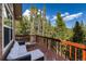 Outdoor lounge furniture on a wooden deck showcasing views of the surrounding lush greenery and clear sky at 302 Texas Dr, Idaho Springs, CO 80452