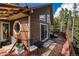 Exterior view of a charming home with a wooden deck, outdoor seating, and scenic natural surroundings at 302 Texas Dr, Idaho Springs, CO 80452