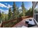 Relaxing outdoor deck area with comfortable seating and views of towering trees against a clear blue sky at 302 Texas Dr, Idaho Springs, CO 80452