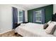 A comfortable bedroom features a full bed, side tables, accent wall, and large windows at 302 Texas Dr, Idaho Springs, CO 80452