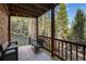 Serene covered deck showcasing outdoor seating, ideal for enjoying the tranquil forest ambiance at 302 Texas Dr, Idaho Springs, CO 80452