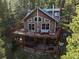 Two story house with large deck and outdoor seating surrounded by trees at 302 Texas Dr, Idaho Springs, CO 80452