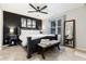 This primary bedroom is equipped with a ceiling fan, king bed, bench and stylish accent wall at 302 Texas Dr, Idaho Springs, CO 80452