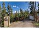 Scenic view of the property from the driveway, showcasing the house, shed, and stunning mountain backdrop at 302 Texas Dr, Idaho Springs, CO 80452