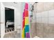 Shower featuring tiled walls, modern fixtures, and colorful shower curtain with a view into the bedroom at 302 Texas Dr, Idaho Springs, CO 80452