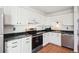 Close up of the kitchen showcasing white cabinets, stainless steel appliances, and dark countertops at 8975 Field St # 39, Broomfield, CO 80021