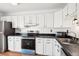 Features of this kitchen include stainless steel appliances, white cabinets, and dark countertops at 8975 Field St # 39, Broomfield, CO 80021