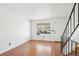 Bright living room with staircase, hardwood floors, and a white front door at 8975 Field St # 39, Broomfield, CO 80021