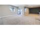 Expansive basement with neutral walls, carpet, and a sliding door leading to a patio with a hot tub at 8661 Hunters Hill Ln, Littleton, CO 80125