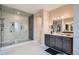 Modern bathroom featuring sleek cabinets, a dual-light vanity, glass shower with shelving, and updated fixtures at 8661 Hunters Hill Ln, Littleton, CO 80125