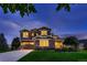 Beautiful two-story home at dusk featuring a well-manicured lawn, stone accents, and inviting curb appeal at 8661 Hunters Hill Ln, Littleton, CO 80125