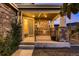 Inviting front porch with stone fireplace, decorative pillars, and cozy seating area at 8661 Hunters Hill Ln, Littleton, CO 80125