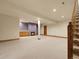 Spacious basement featuring a fireplace, built-in cabinets, and stairs to the upper level at 6321 S Harrison Ct, Centennial, CO 80121
