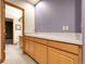 Basement wet bar area featuring light wood cabinets, sink, and a view into an adjoining bathroom at 6321 S Harrison Ct, Centennial, CO 80121