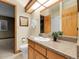 Bright bathroom featuring a sink with a granite countertop and natural wood cabinets at 6321 S Harrison Ct, Centennial, CO 80121