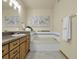 Bathroom featuring a bathtub with tile surround, vanity with sink, and neutral decor at 6321 S Harrison Ct, Centennial, CO 80121