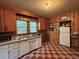 Retro kitchen with white appliances, wood cabinets, and checkered tile flooring at 240 N 4Th Ave, Brighton, CO 80601